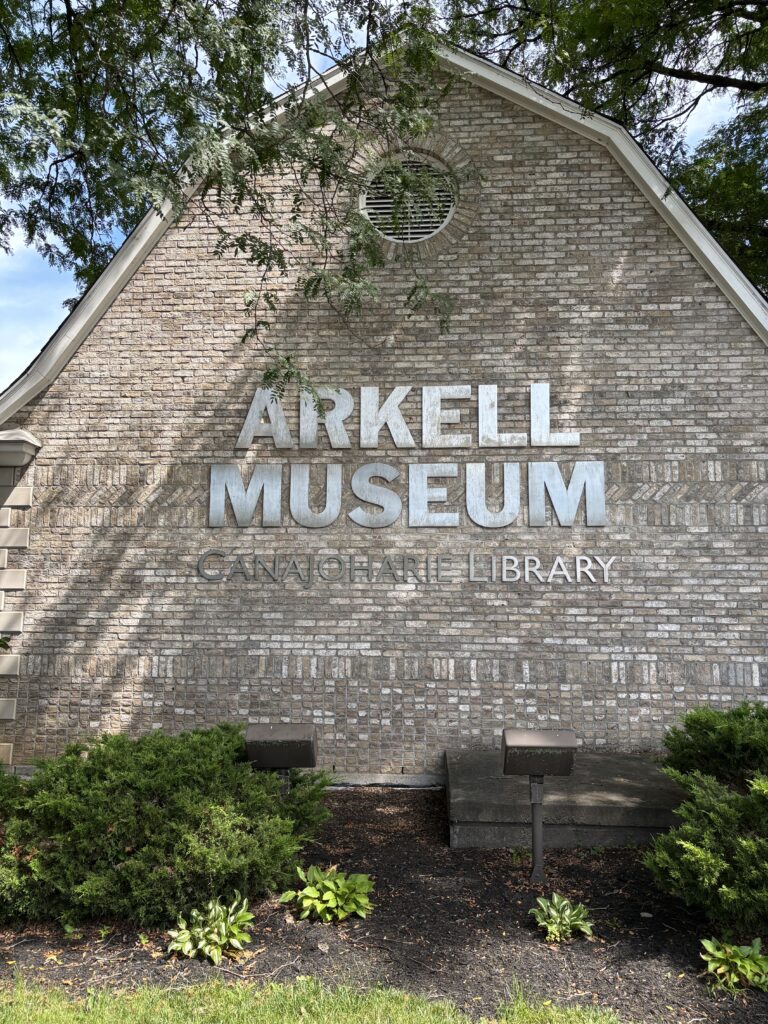 Photos of the side of a building with signage saying "Arkell Museum, Canajoharie Library"